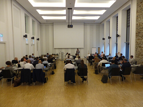 Personen in einem Konferenzraum auf einer Präsenzveranstaltung des BHUK